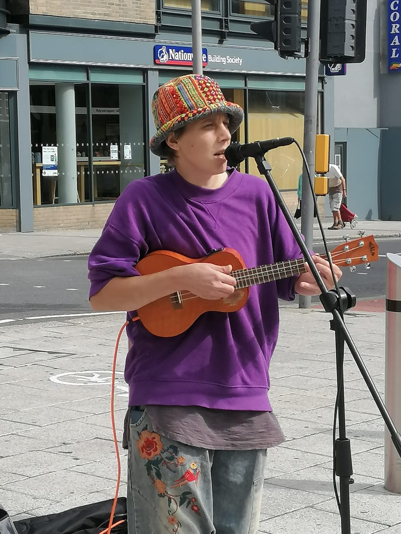 Fragile Lucy busking in a purple jumper and knitted hat