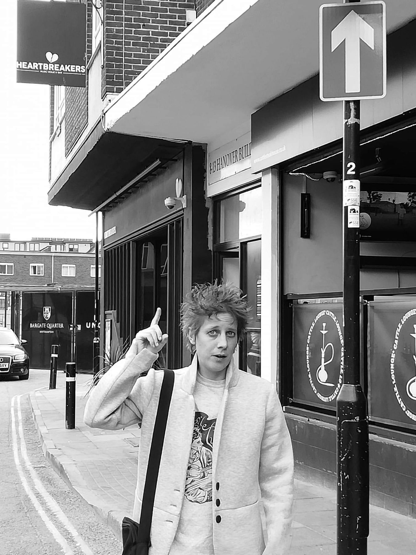 Fragile Lucy on a city street pointing upwards