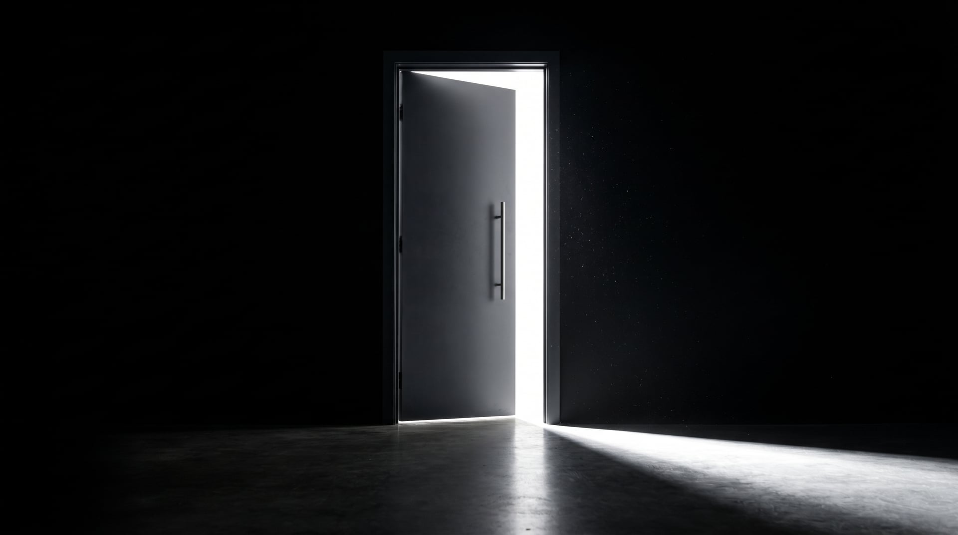 A charcoal door standing ajar in the dark, with white light spilling through the gap on to the floor