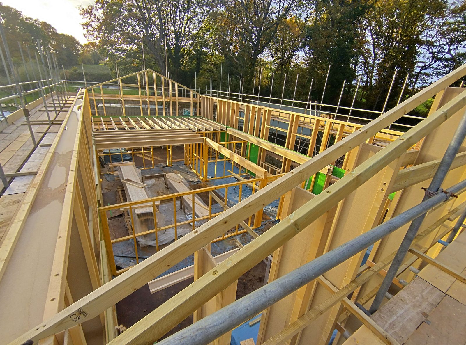 Timber frame of a new Passivhaus seen from the scaffold at sunrise
