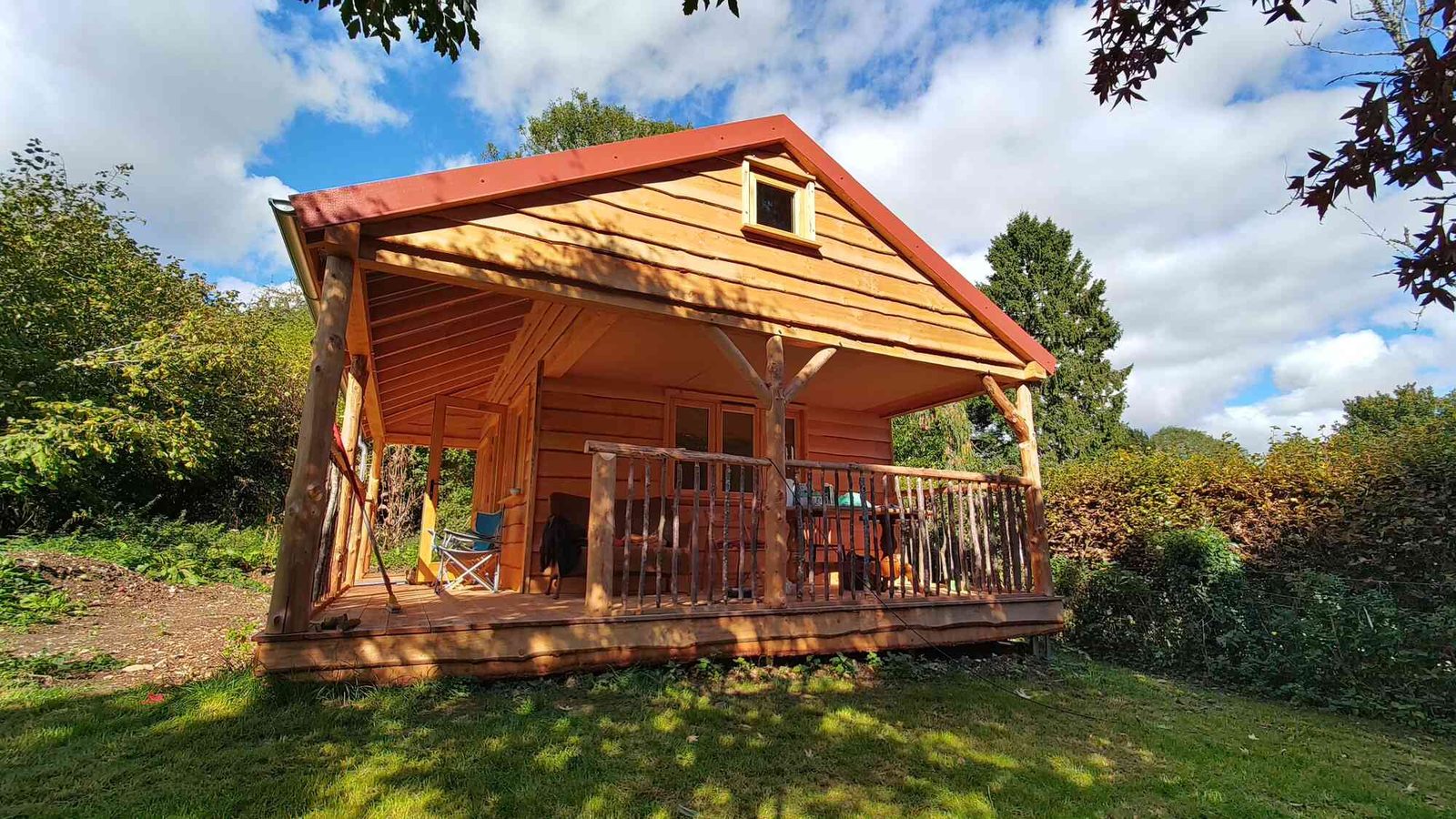 Finished cabin with roundpole veranda in a garden